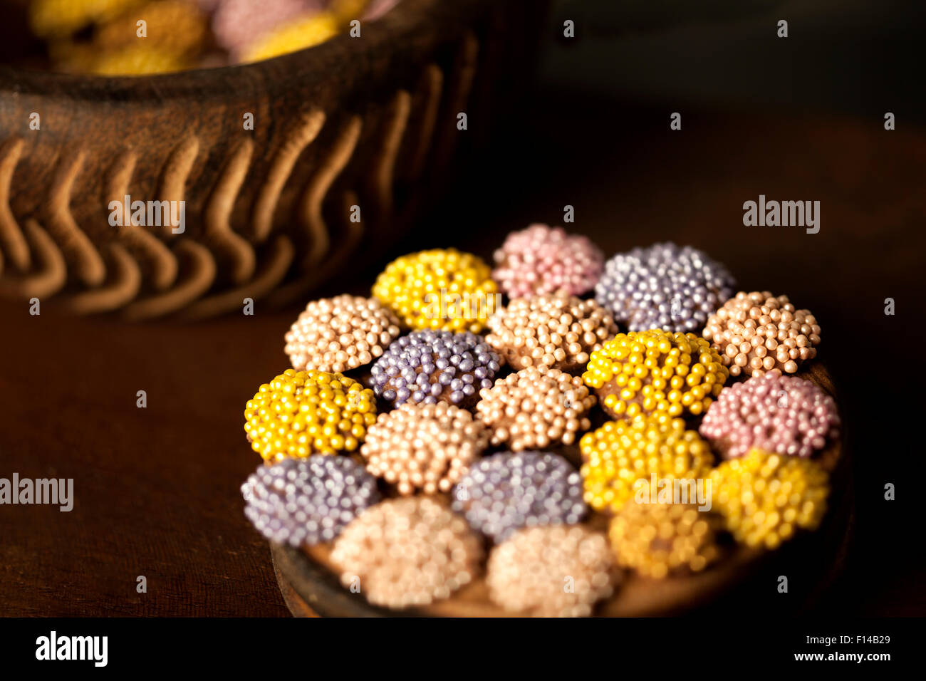 Colorati confetti di cioccolato posto su una superficie di legno. Foto Stock