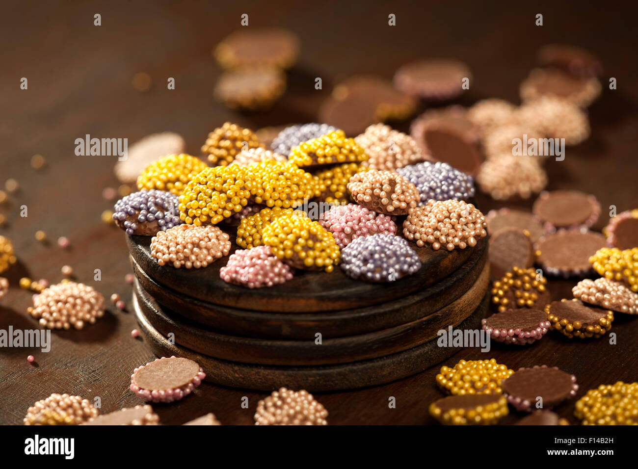 Colorati confetti di cioccolato collocato in una superficie di legno. Foto Stock