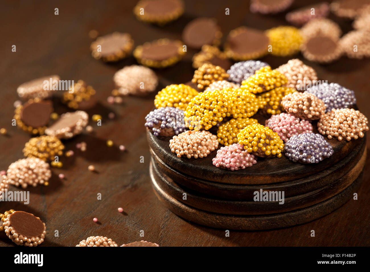 Colorati confetti di cioccolato collocato in una superficie di legno. Foto Stock