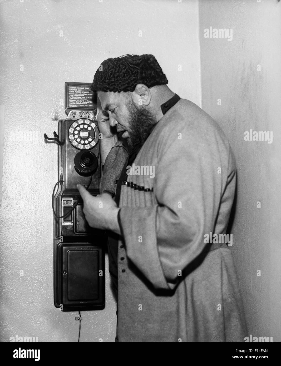 1930s uomo musulmano tramite telefono a pagamento Foto Stock