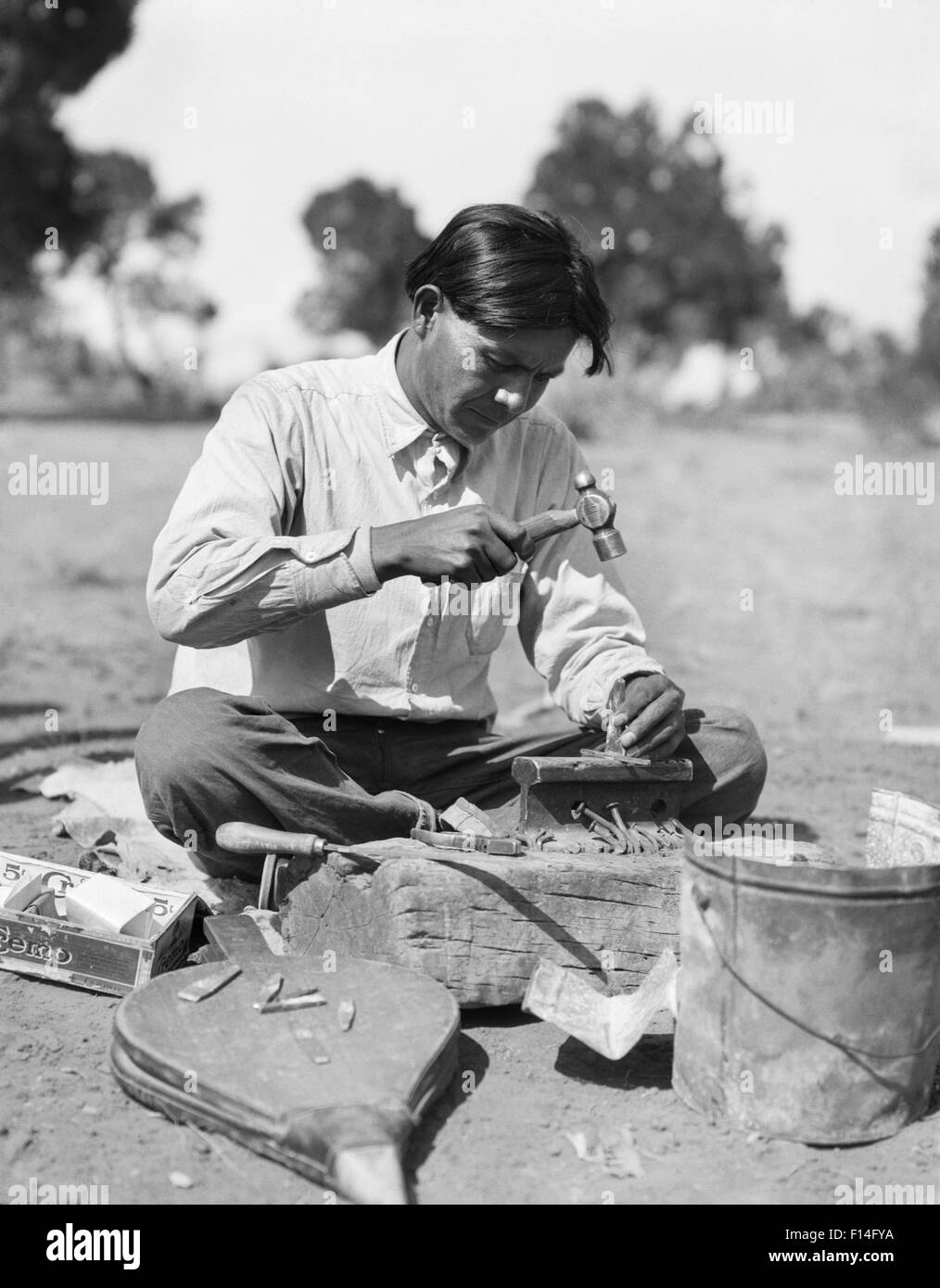 1920s Native American Indian NAVAJO uomo artigiano argentiere rendendo gioielli tradizionali NUOVO MESSICO USA Foto Stock