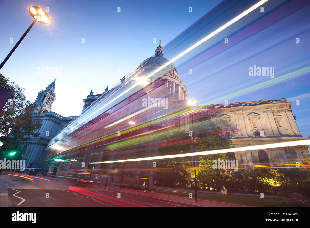 Un illuminato sfocato double decker bus la Cattedrale di St Paul e al crepuscolo, Central London, England, Regno Unito Foto Stock