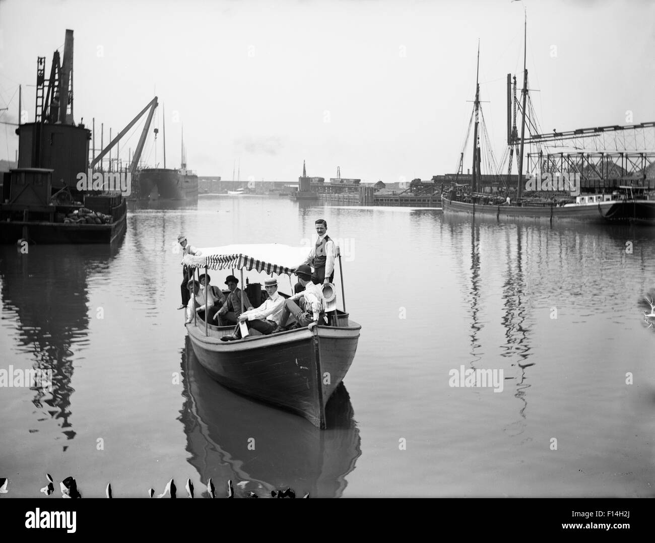 1900s svolta del ventesimo secolo un gruppo di uomini in piccola barca il giorno vicino al City Wharf Foto Stock