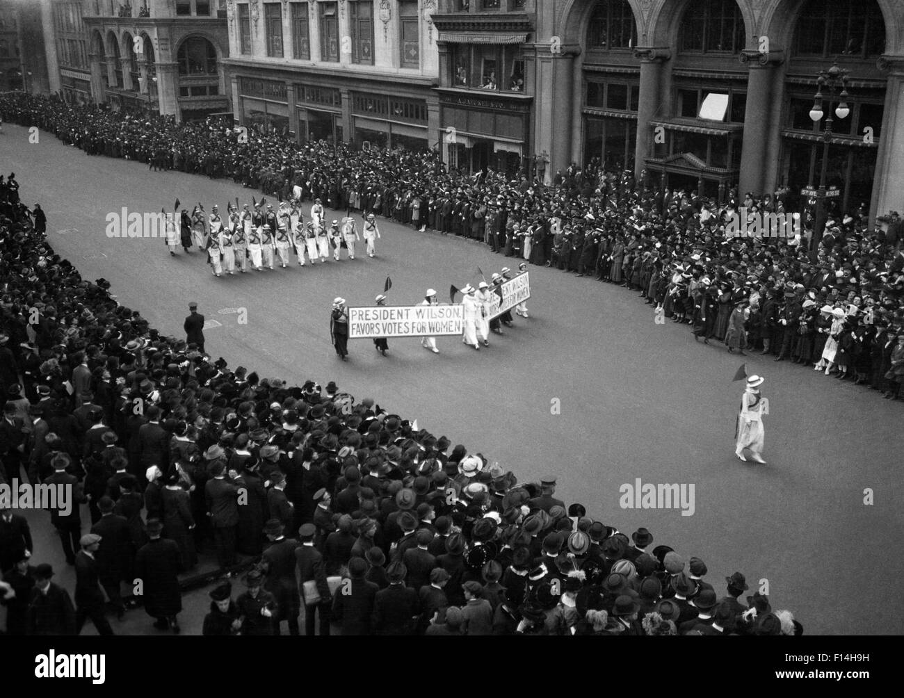 1910s vista aerea di una grande folla a guardare la gente marciando in un corteo di suffragio circa 1914 Foto Stock