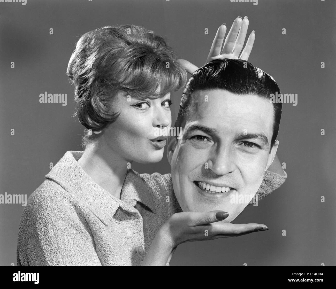 Anni Cinquanta anni sessanta donna AZIENDA LIFE-SIZE FOTO dalla testa dell'uomo nelle sue mani il raggrinzimento labbra da baciare Foto Stock