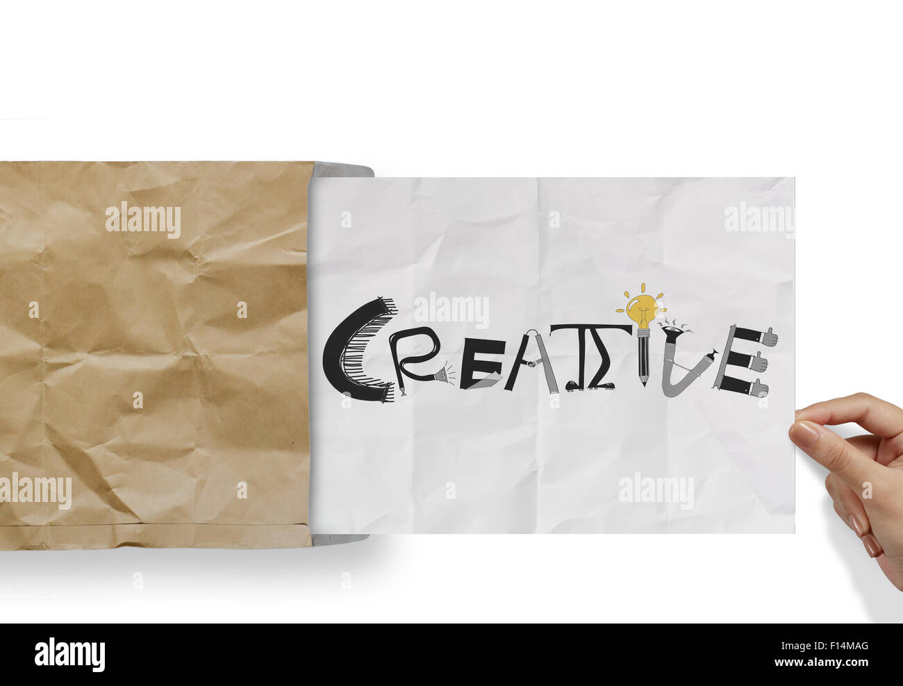 La mano tirando la carta stropicciata dalla busta con parola di design creativo come concetto Foto Stock