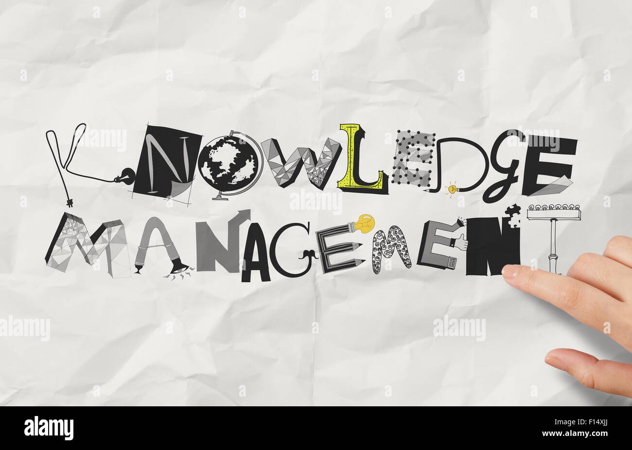 Imprenditore mano design di puntamento parola knowledge management su carta sgualcita come concetto Foto Stock
