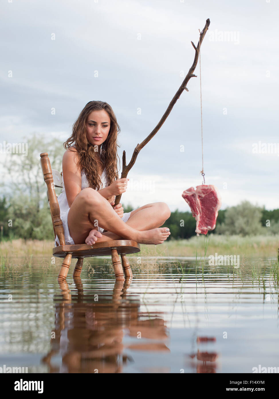 Stati Uniti d'America, Utah, Provo, donna seduta su una sedia nel lago e la pesca Foto Stock
