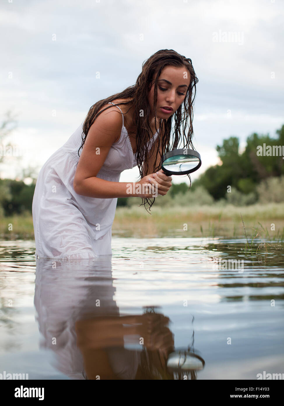 Stati Uniti d'America, Utah, Provo, donna guadare in lago con lente di ingrandimento Foto Stock