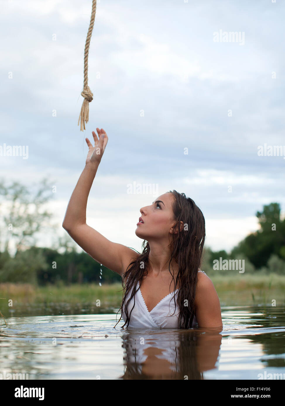 Stati Uniti d'America, Utah, Provo, donna guadare in lago raggiungendo per la corda sopra la testa Foto Stock