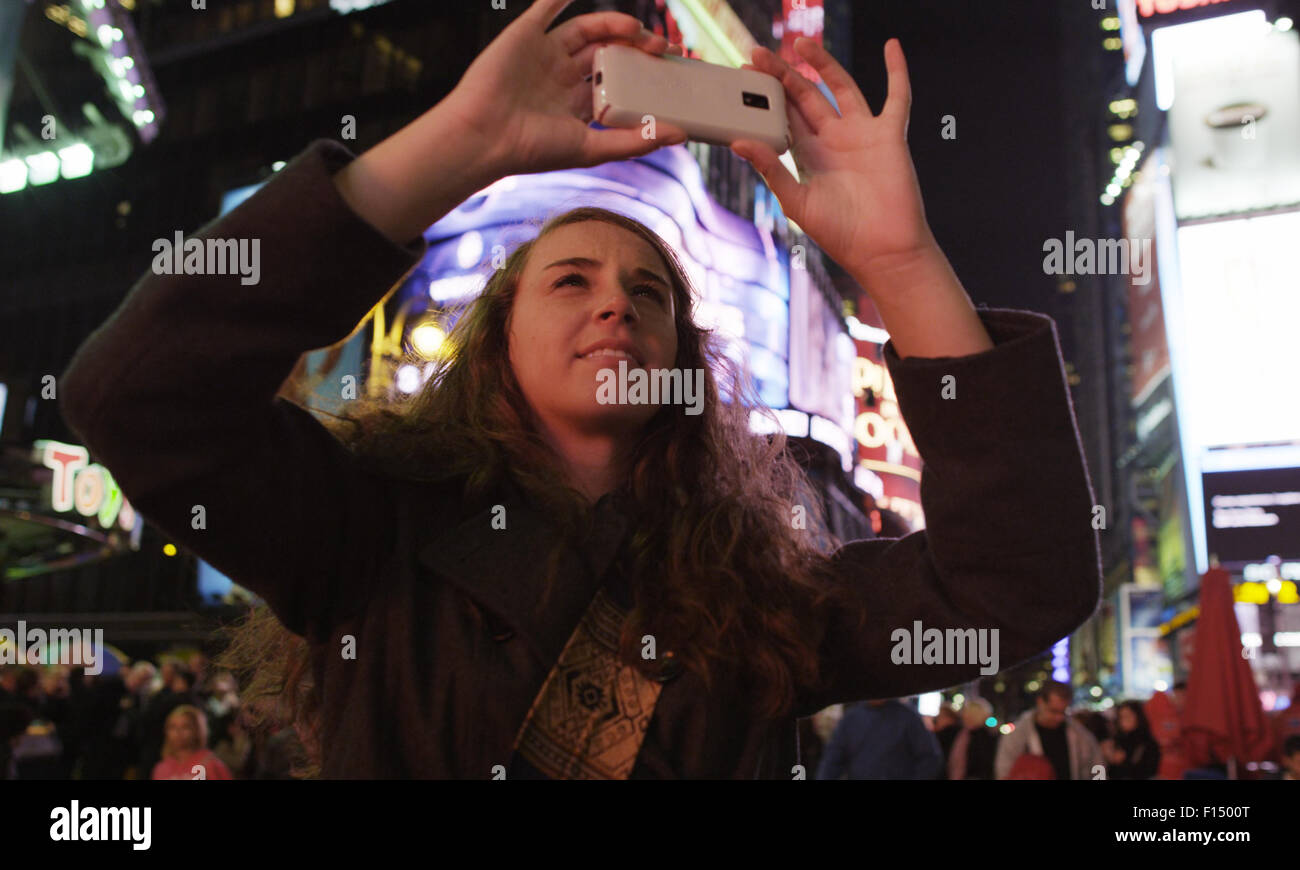 Donna scattano fotografie in Times Square a New York City Foto Stock