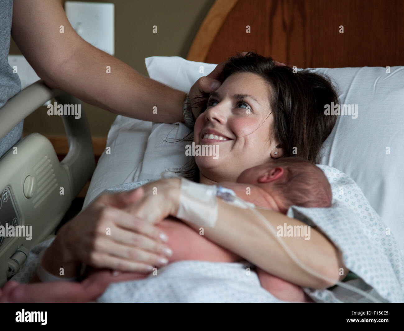 Stati Uniti d'America, Utah, Payson, Madre abbracciando baby boy (0-1 mesi) a letto Foto Stock