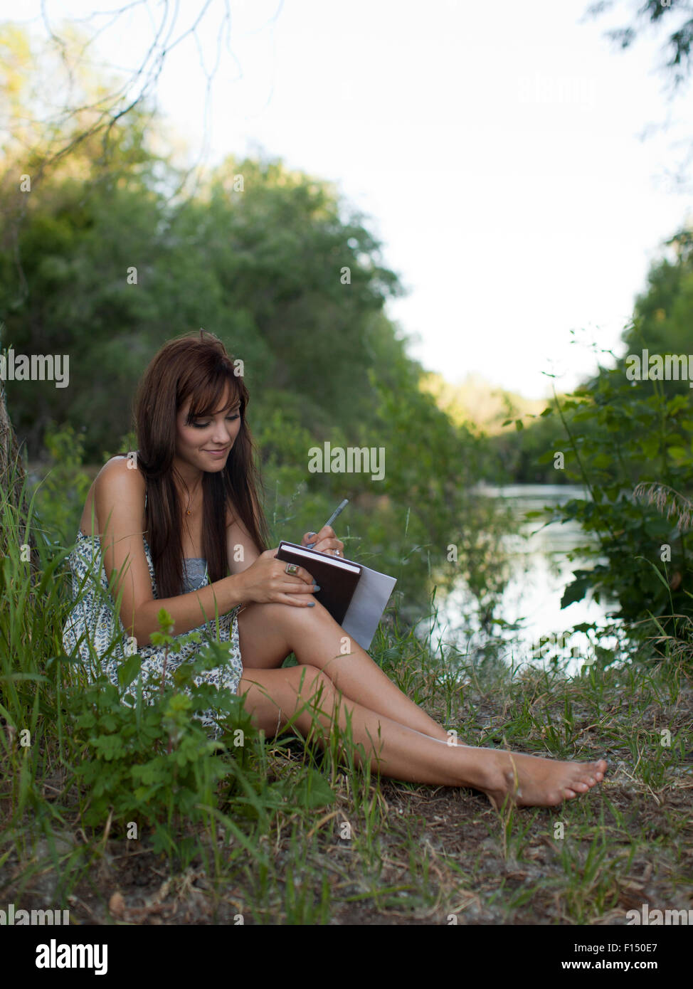 Stati Uniti d'America, Utah, Provo, donna seduta dal lago note facendo Foto Stock