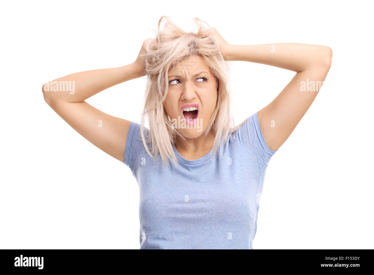 Frustrati giovane donna tirando i suoi capelli e urlando isolati su sfondo bianco Foto Stock