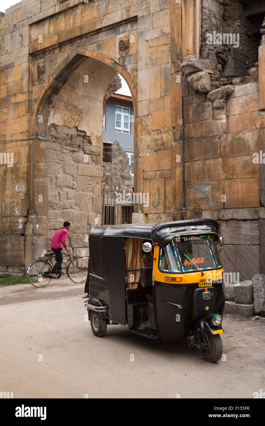India, Jammu e Kashmir Srinagar, autorickshaw parcheggiato a resti di Mughal porta ad arco nelle vecchie mura della città Foto Stock