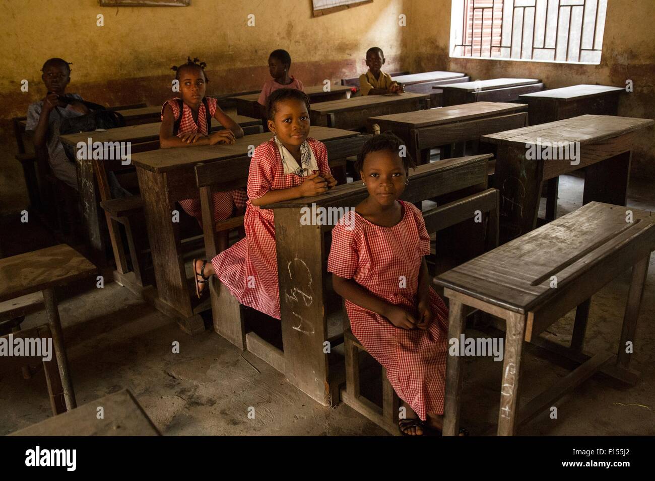 I giovani studenti a sedersi in un gran parte in aula vuota come scuole riaperte dopo che essi sono stati chiusi per tre mesi durante l'epidemia di Ebola Gennaio 19, 2015 a Conakry, in Guinea. Più di 80.000 insegnanti di pre-primario a livelli universitari sono stati addestrati a contribuire alla lotta contro l'epidemia. Foto Stock