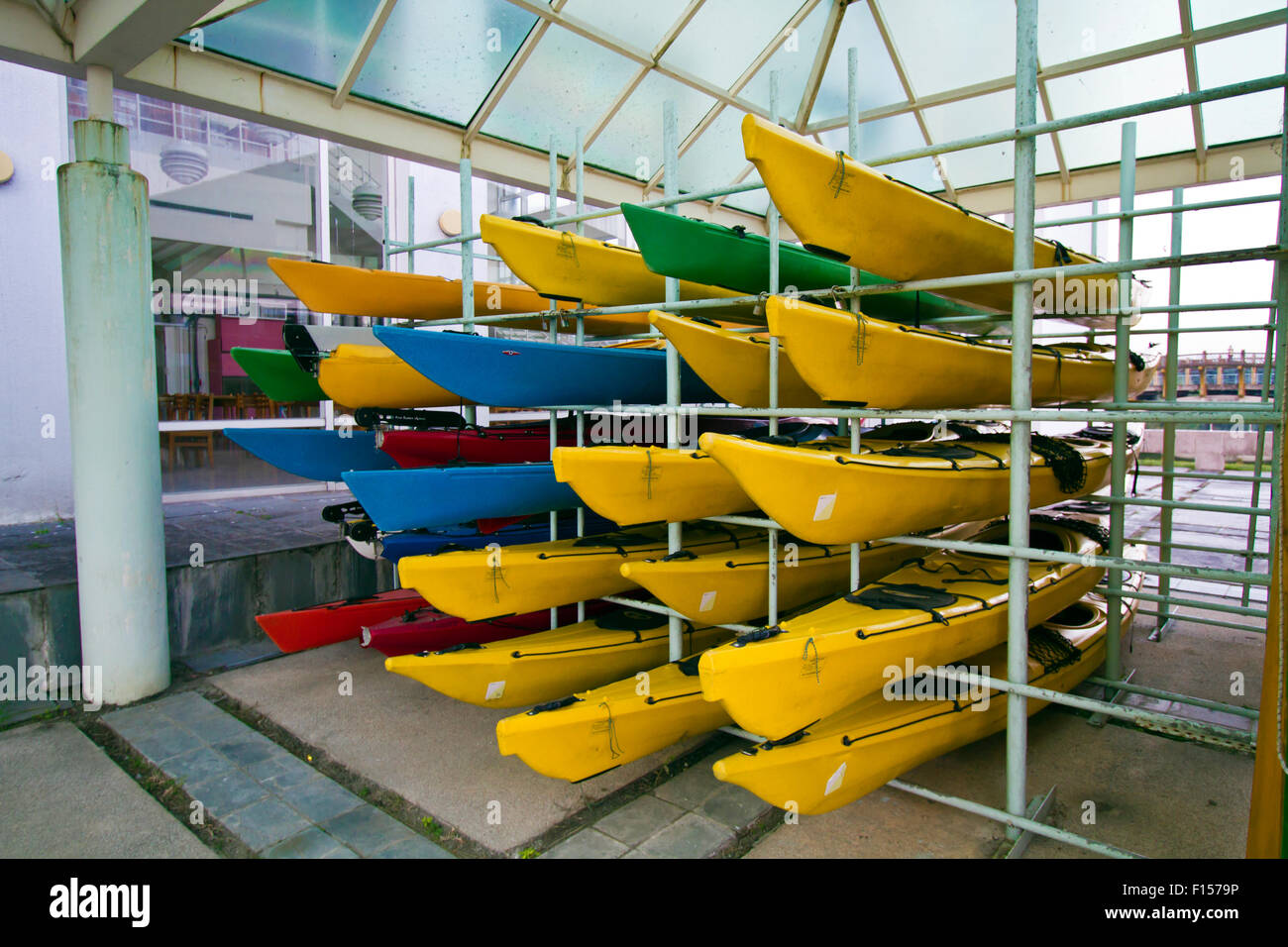 Array di canoe colorate sul framework Foto Stock