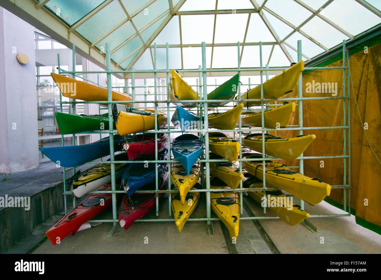 Array di canoe colorate sul framework Foto Stock