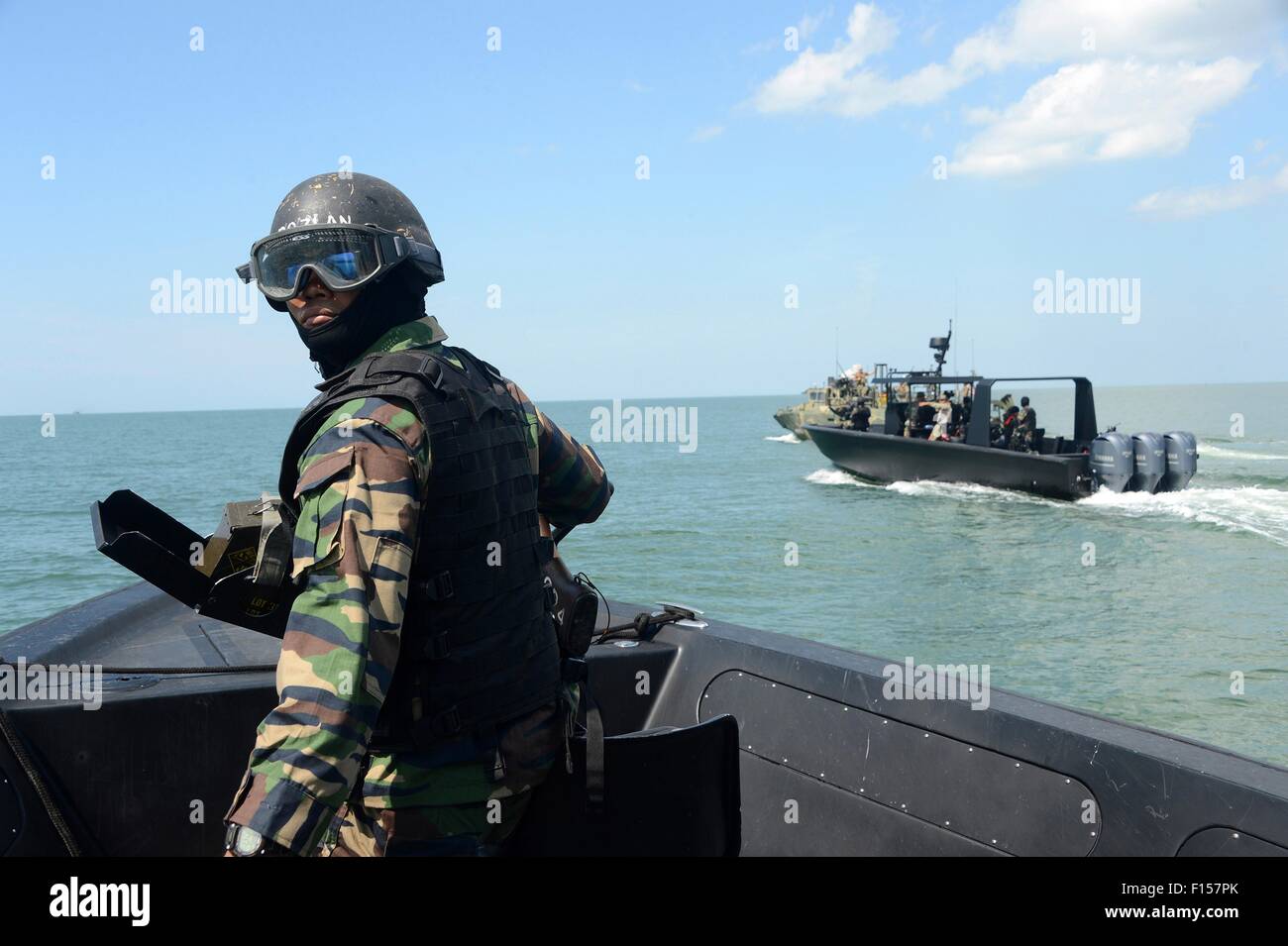 Un reale malese operazione speciale commando mans una mitragliatrice durante la barca la tattica della formazione con gli Stati Uniti Navy SEALs con la costiera squadrone fluviale 4 durante il carrello Malaysia esercizi di addestramento Agosto 17, 2015 in Sandakan, Malaysia. Foto Stock