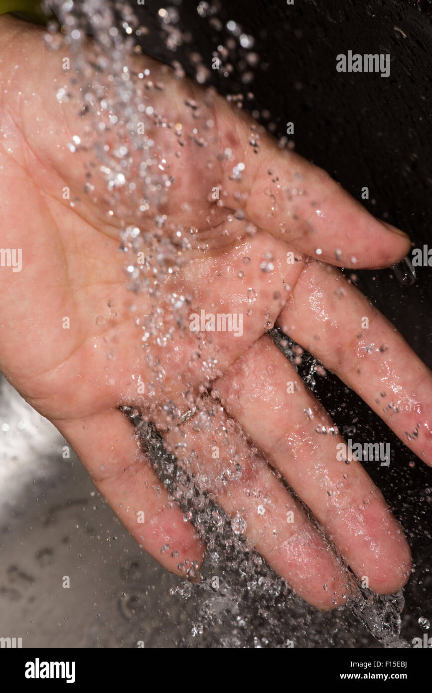 Mano di donna sotto acqua corrente del rubinetto Foto Stock