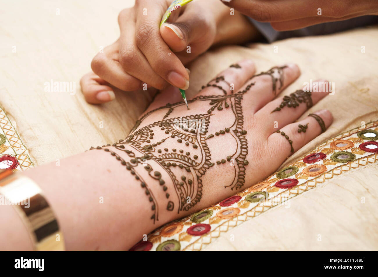 Motivi di henné, mano che viene decorata / tatuata con hena. Pittura all' henné. Decorazioni a mano all'henné. Mani all'henné Foto stock - Alamy