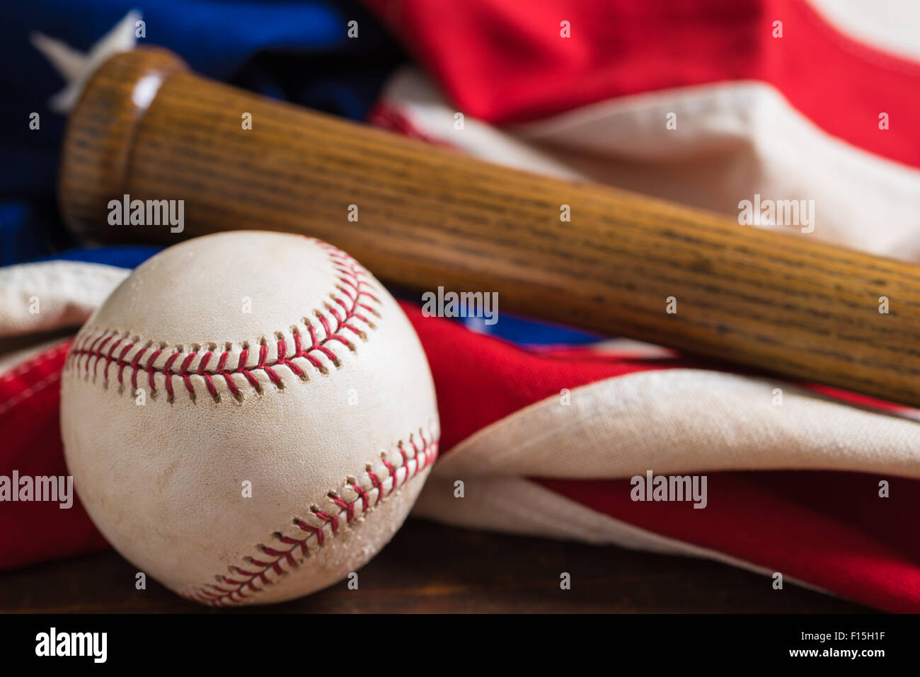 Un vecchio, antichi bandiera americana con vintage attrezzatura da baseball su una panca in legno Foto Stock