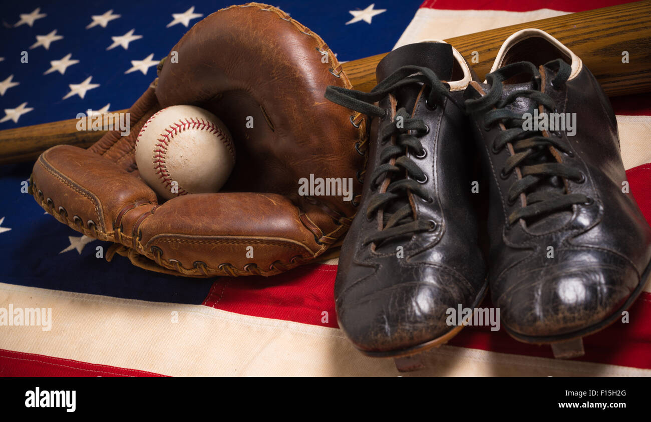 Un vecchio, antichi bandiera americana con vintage attrezzatura da baseball su una panca in legno Foto Stock