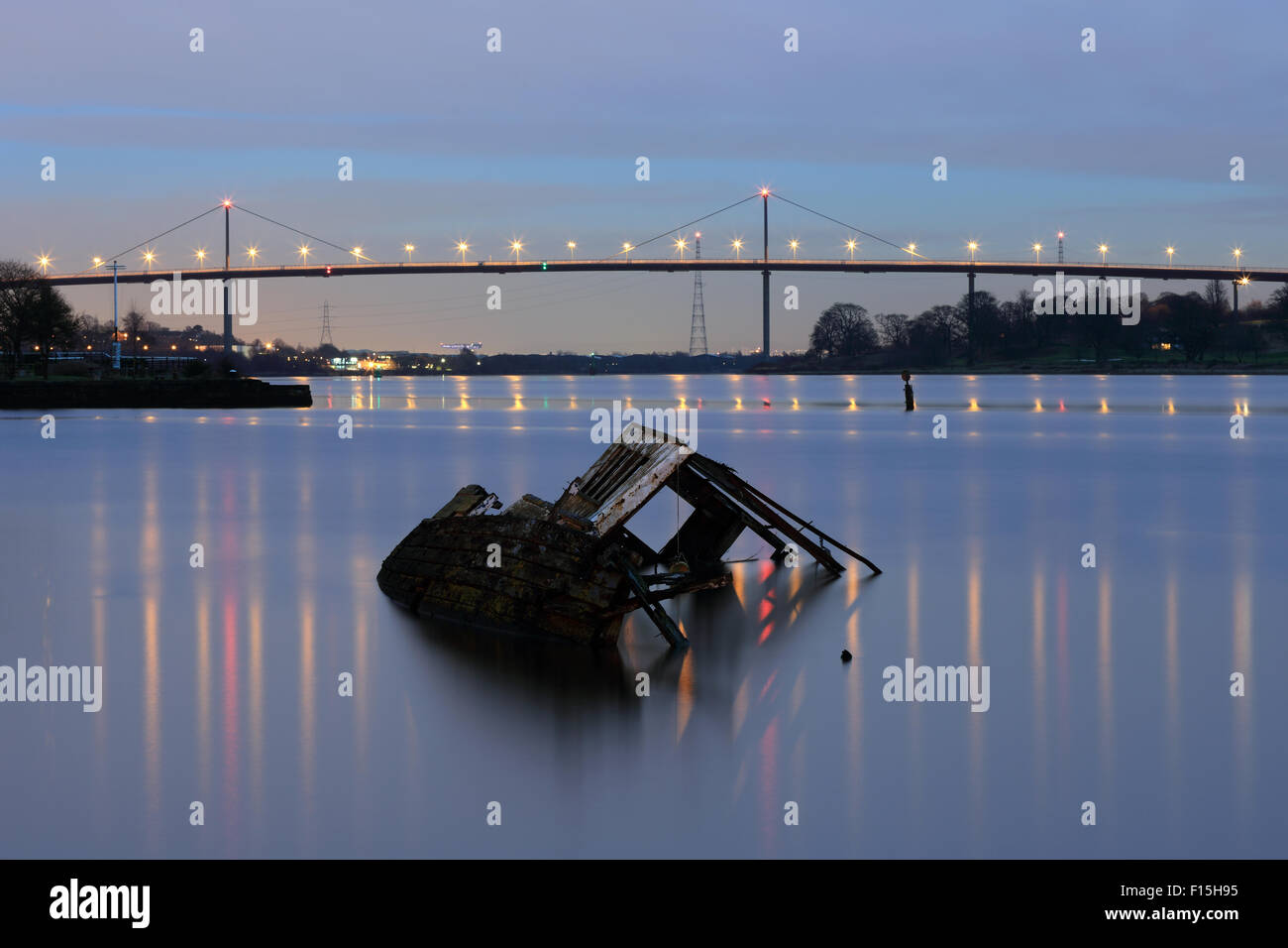 Relitto di nave dal porto di Bowling con Erskine Bridge in background al tramonto Foto Stock