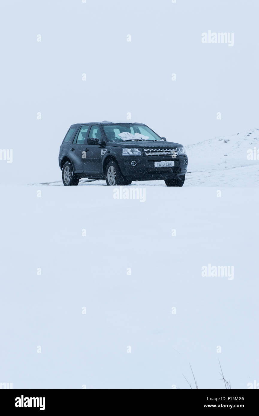 Nero 4x4 set contro il bianco sullo sfondo innevato - Land Rover Freelander 2 veicolo a quattro ruote motrici parcheggiato nella neve in inverno - Yorkshire, Inghilterra, Regno Unito. Foto Stock