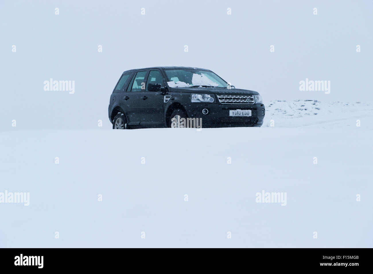 Nero 4x4 set contro il bianco sullo sfondo innevato - Land Rover Freelander 2 veicolo a quattro ruote motrici parcheggiato nella neve in inverno - Yorkshire, Inghilterra, Regno Unito. Foto Stock
