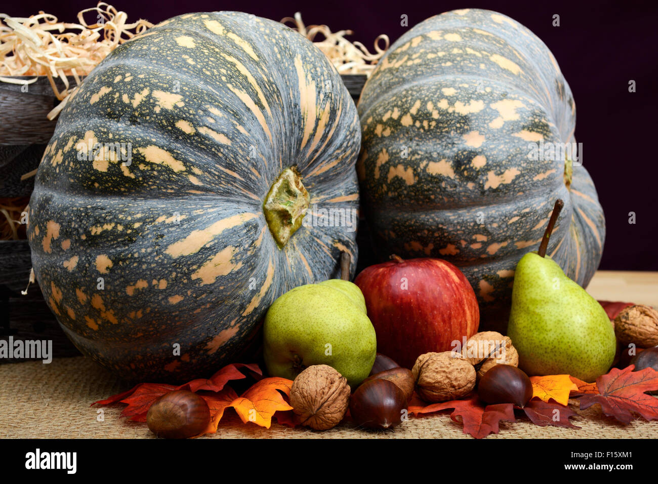 Stile rustico autunno raccolto autunnale zucche, frutta a guscio e la frutta con gabbia di stoccaggio per il giorno del Ringraziamento o di Halloween. Foto Stock