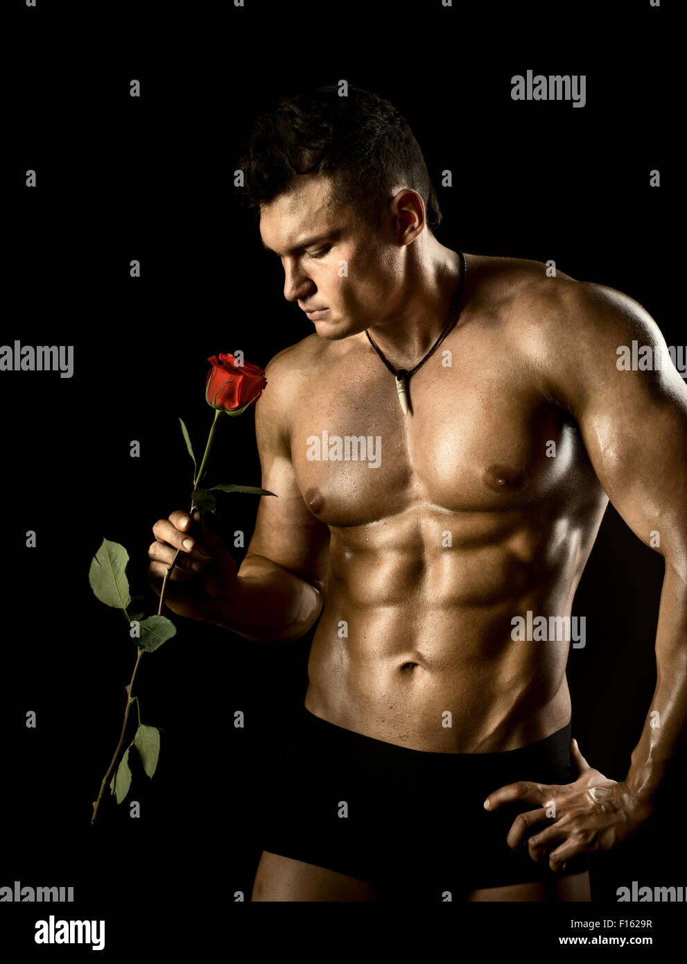 Il muscoloso bello sexy guy su sfondo nero, torso nudo Foto Stock