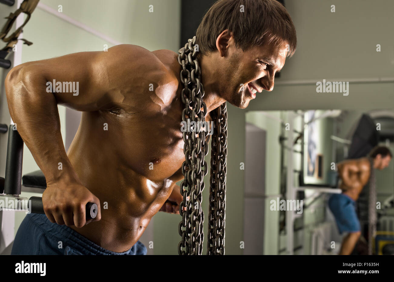 Molto potere athletic guy , eseguire esercizio sulle barre parallele, allenarvi nella sala di sport Foto Stock