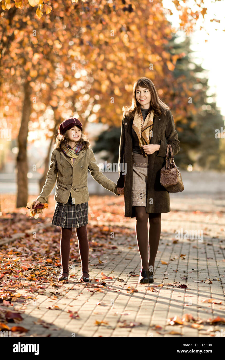 Foto verticale, felice bellissima bambina con mather passeggiate nel parco Foto Stock
