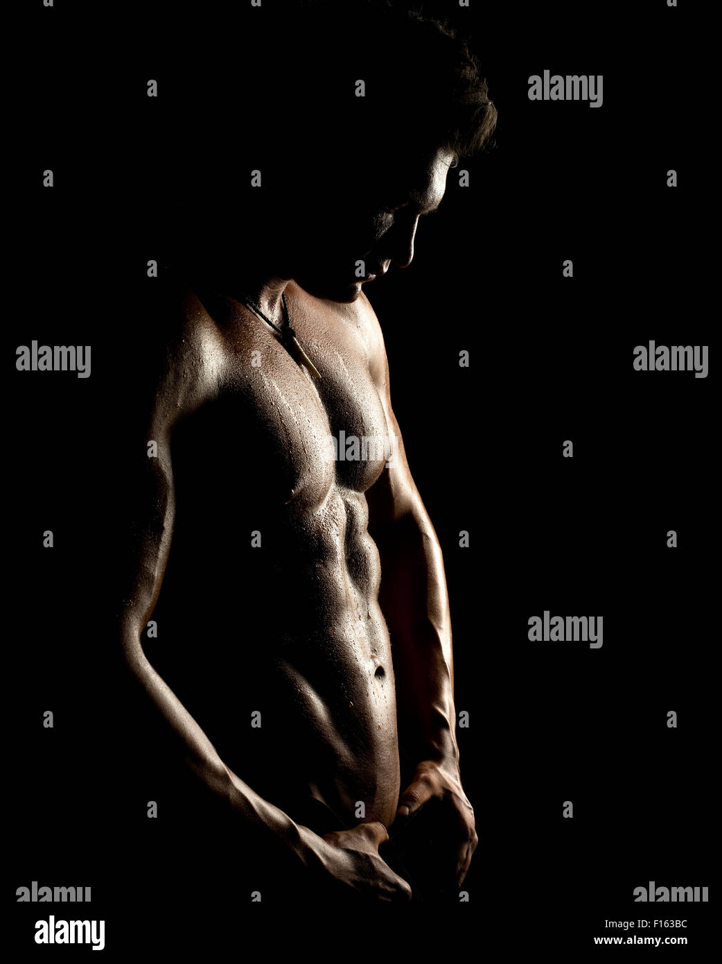 Il muscoloso bello sexy guy su sfondo nero, torso nudo Foto Stock