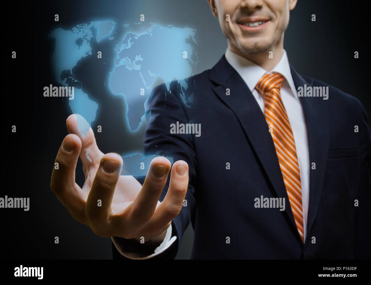 Imprenditore tenere raggiungere fuori mano , su sfondo blu scuro, concetto di business Foto Stock