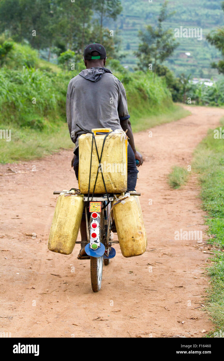 Ragazzo porta grandi brocche in bicicletta per ottenere acqua a novembre 4; 2013. Foto Stock