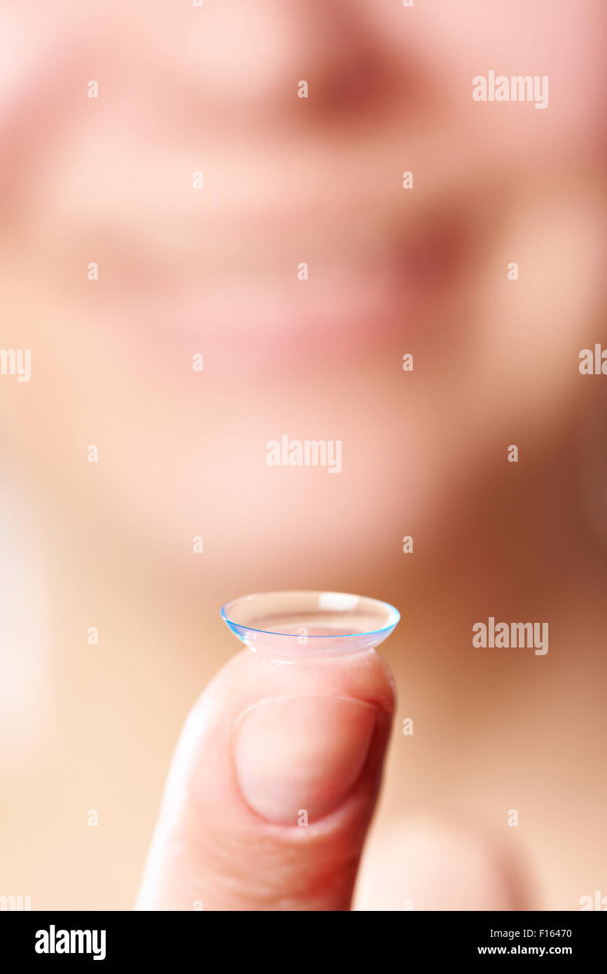 La medicina e la visione - womans dito con lente a contatto Foto Stock