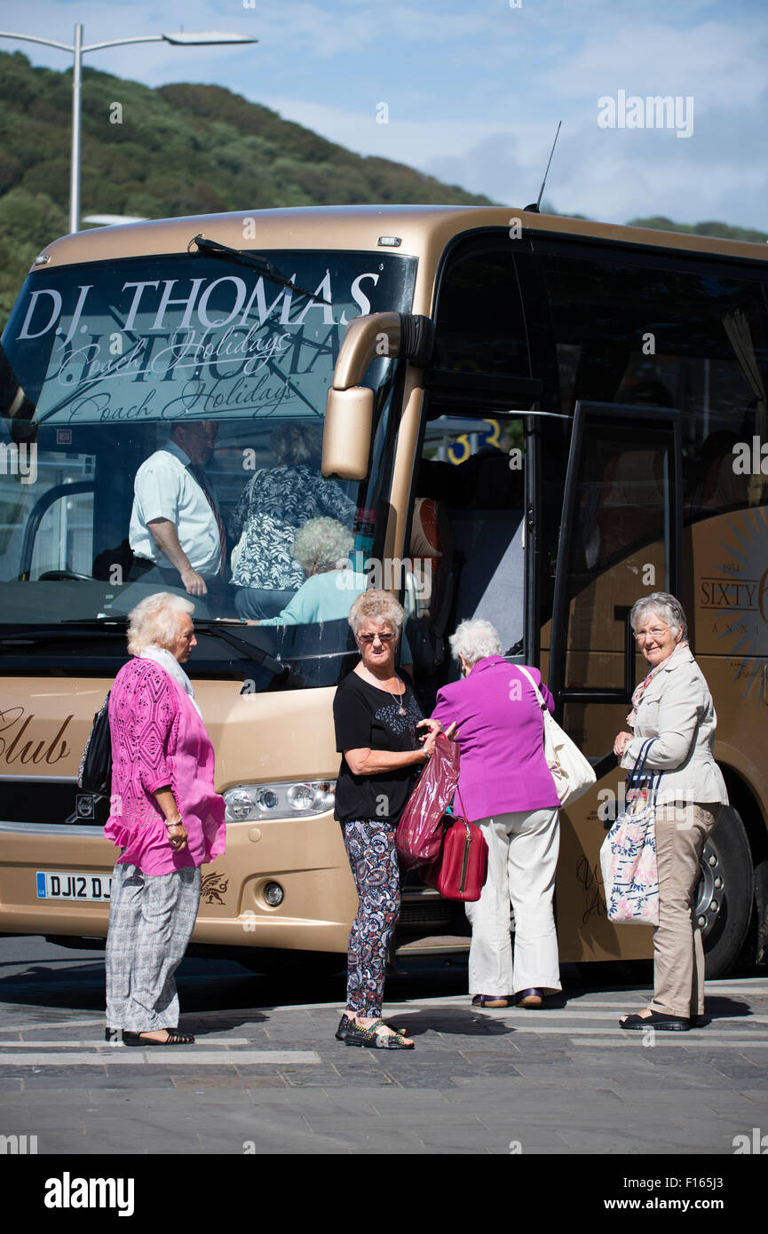 Quattro le donne anziane i turisti di salire a bordo di un autobus autobus per andare per una gita di un giorno di viaggio escursione, REGNO UNITO Foto Stock