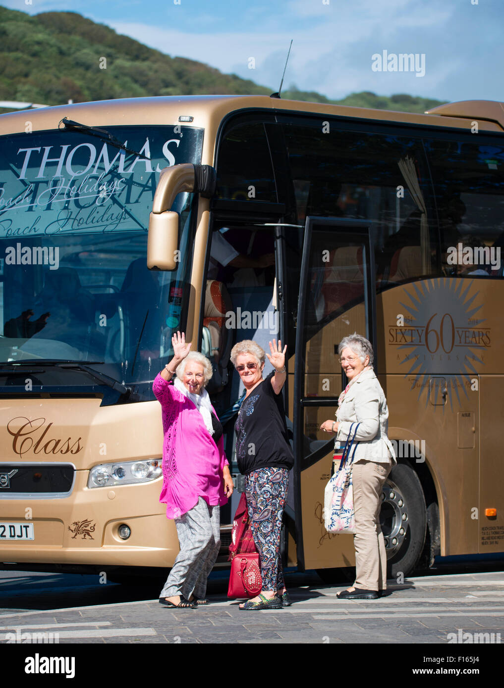 Tre donne Senior turisti sventolando come essi a bordo di un autobus autobus per andare per una gita di un giorno di viaggio escursione, REGNO UNITO Foto Stock Tre donne Senior turisti sventolando come essi a bordo di un autobus autobus per andare per una gita di un giorno di viaggio escursione, REGNO UNITO Foto Stock
