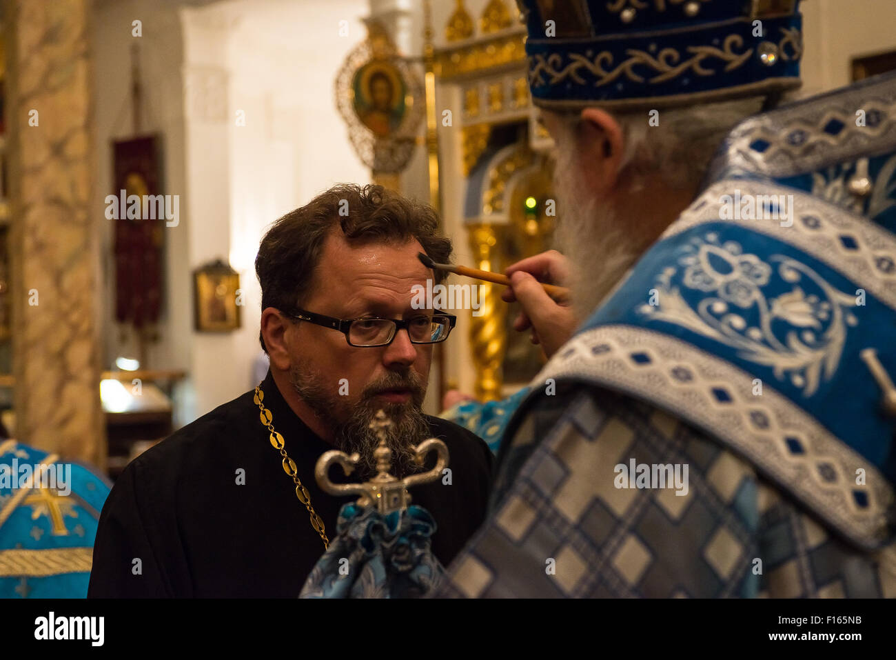 Un sacerdote è unto con olio visitando il Vescovo Gabriele di Montreal. Alla vigilia della festa della Dormizione della Vergine; la dodicesima e ultima 'Grande Festa' nel calendario ecclesiastico; un servizio di veglia si è svolta presso la Cattedrale di sinodale per la Chiesa Ortodossa Russa fuori della Russia, officiata dal Vescovo Nicola di Manhattan e visita di Mons. Gabriel di Montreal. Foto Stock