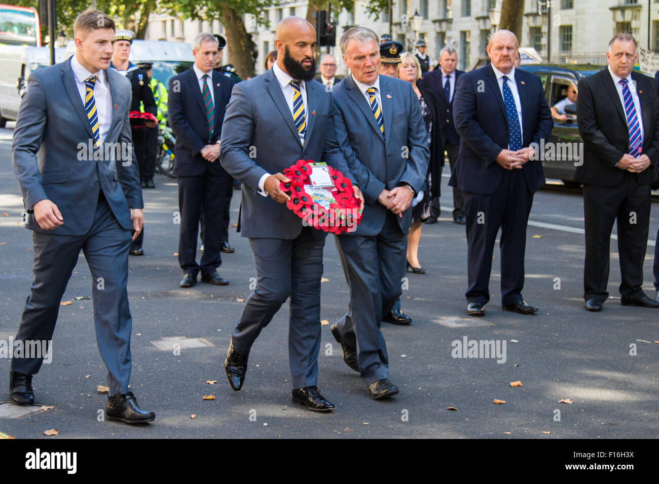 Whitehall, Londra, Regno Unito. 28 Agosto, 2015. Sei corone sono previste presso il Cenotafio dai rappresentanti delle Forze Armate, il team RFL, il parlamentare della Lega di rugby e gruppo Ladbrokes Challenge Cup finalisti Hull Kingston Rovers e Leeds rinoceronti, precedendo di sabato il Ladbrokes Challenge Cup finale a Wembley. Nella foto: Leeds rinoceronti Chief Executive Gary Hetherington (R) e i giocatori Jamie Jones-Buchanan e Liam Sutcliffe (L) stabiliscono la loro corona. Credito: Paolo Davey/Alamy Live News Foto Stock