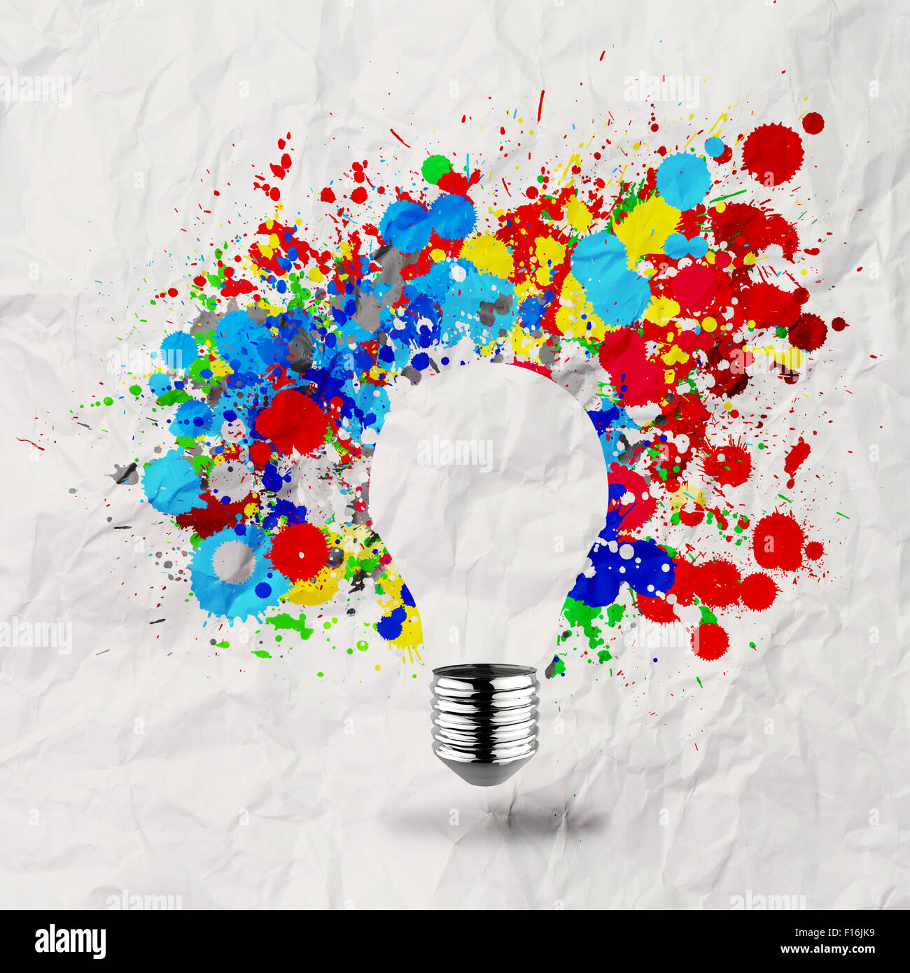 La luce invisibile lampadina e splash di colori su carta sgualcita come concetto creativo Foto Stock