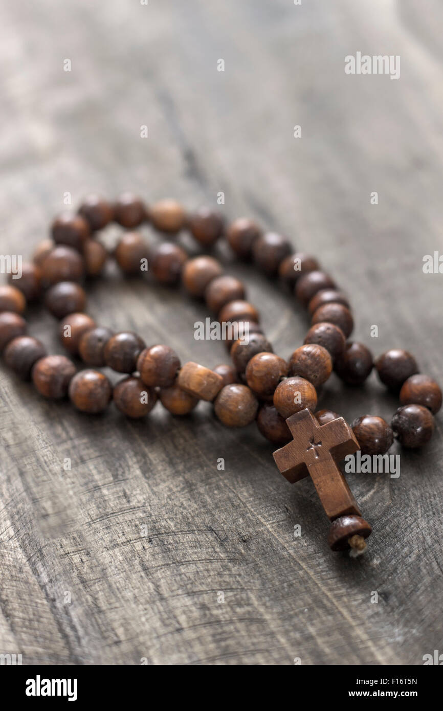 Rosario in legno talloni sul vecchio sfondo di legno, close up Foto Stock