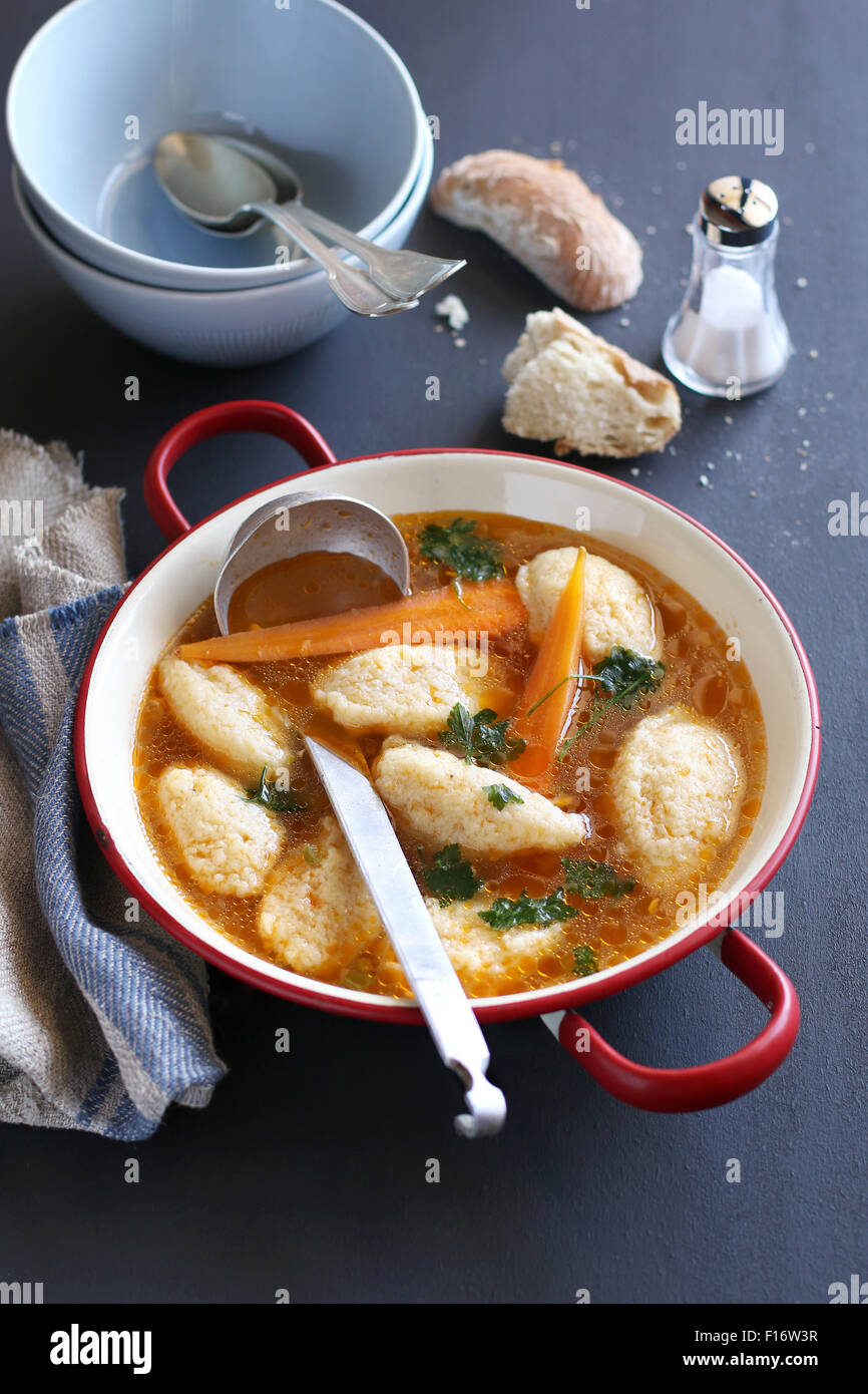 Brodo con gnocchi di semolino in un tegame di smalto Foto Stock