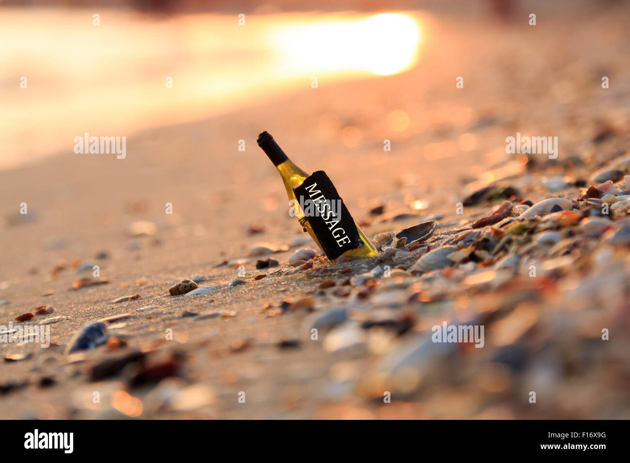Messaggio in bottiglia. Bottiglia con l'iscrizione, Tramonto, Spiaggia. Foto Stock
