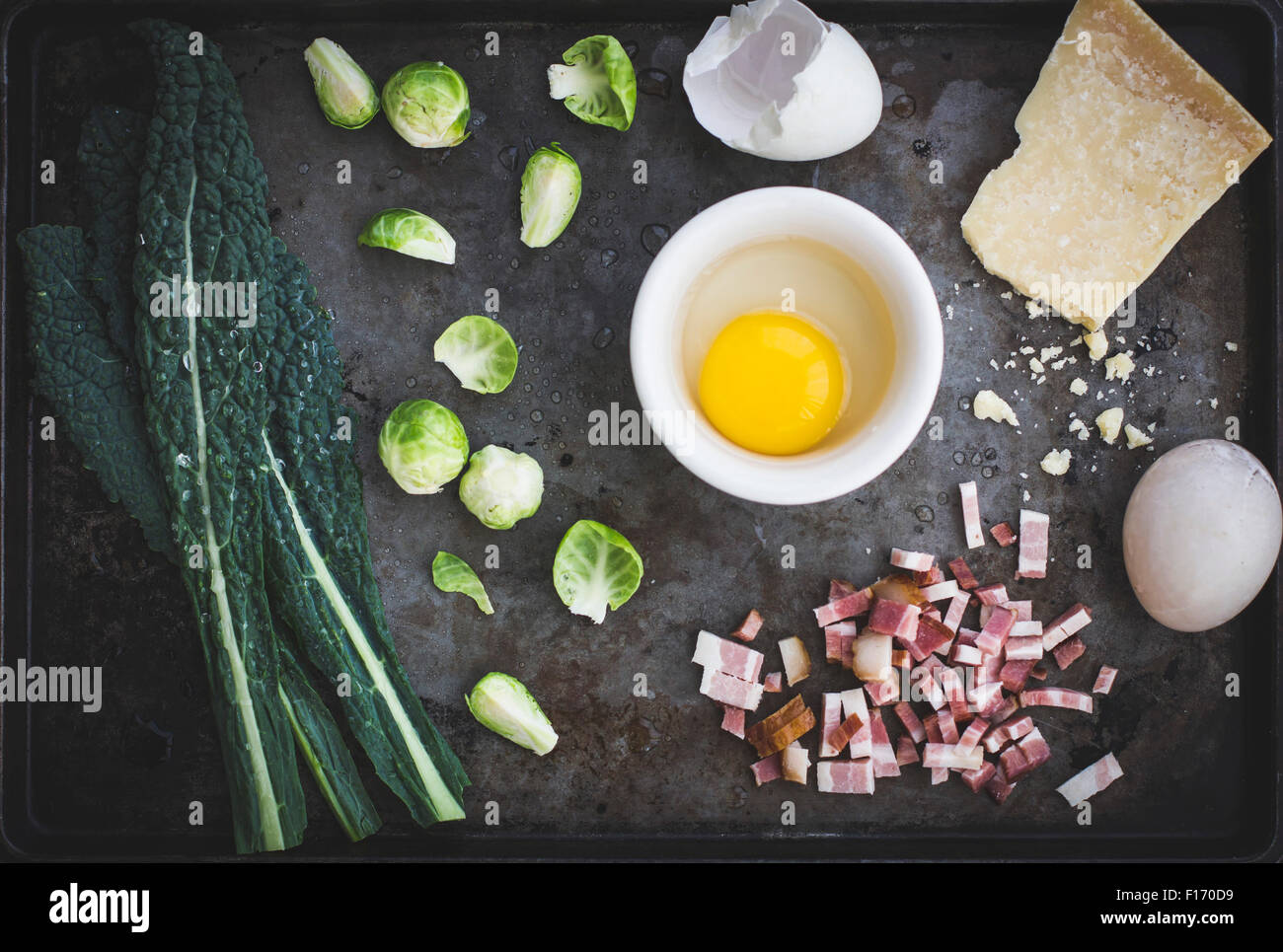 Cavolo riccio, i cavoli di Bruxelles, pancetta, uova e formaggio parmigiano sul pianale in metallo Foto Stock