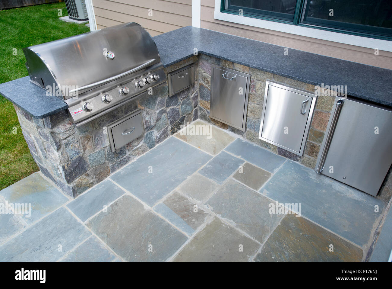 Grill esterno e refrigerazione nel cortile di casa con lastricato e ripiani in granito Foto Stock