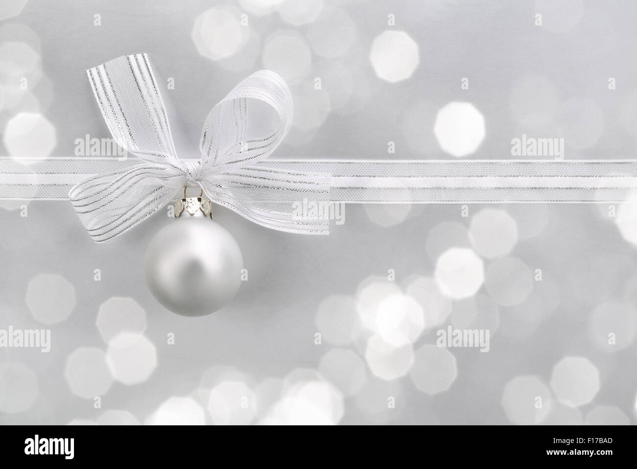 Bianco argento palla di Natale con nastro su sfondo astratto Foto Stock Bianco argento palla di Natale con nastro su sfondo astratto Foto Stock
