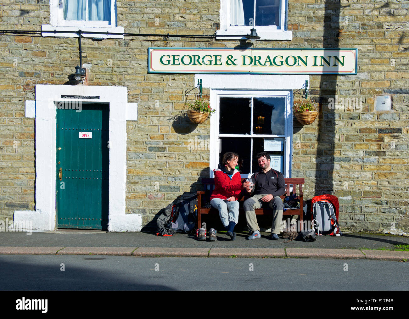 Due Pennine Way walkers seduto fuori il George and Dragon pub, nel villaggio di Garrigil, Cumbria, England Regno Unito Foto Stock